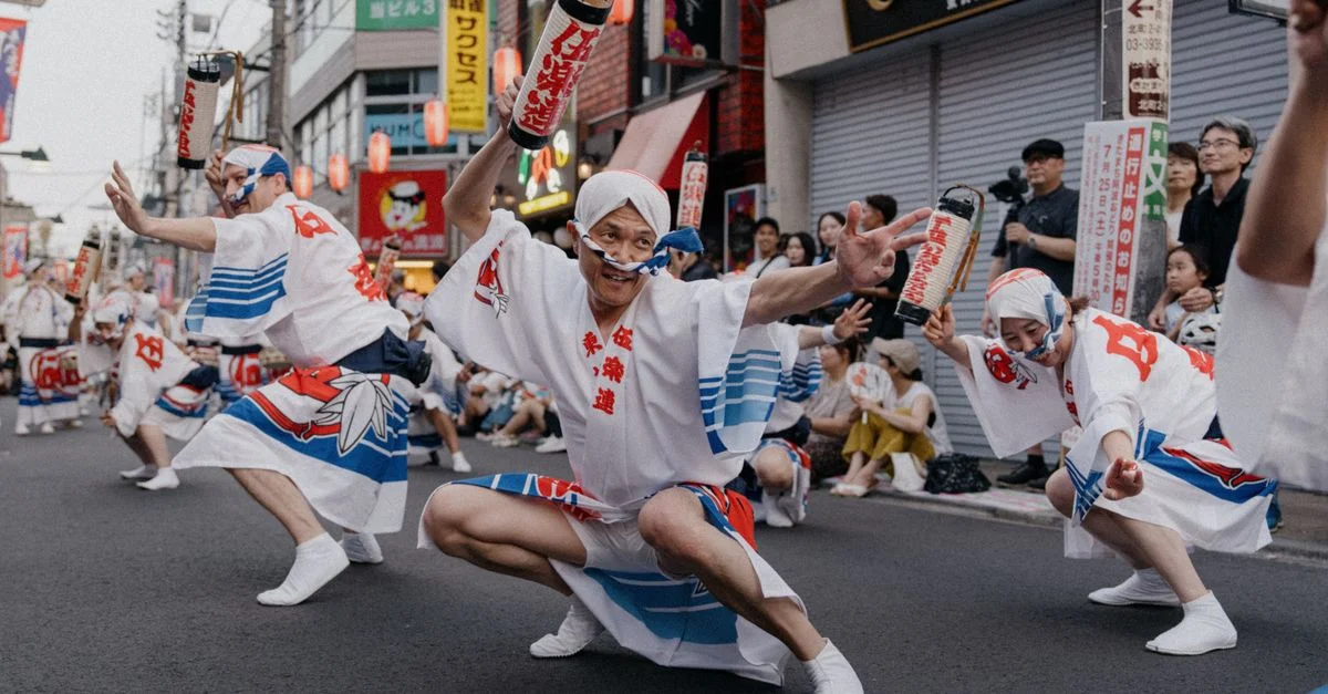 Des danseurs japonais traditionnels en costumes chatoyants se produisent lors d'un festival de rue animé.