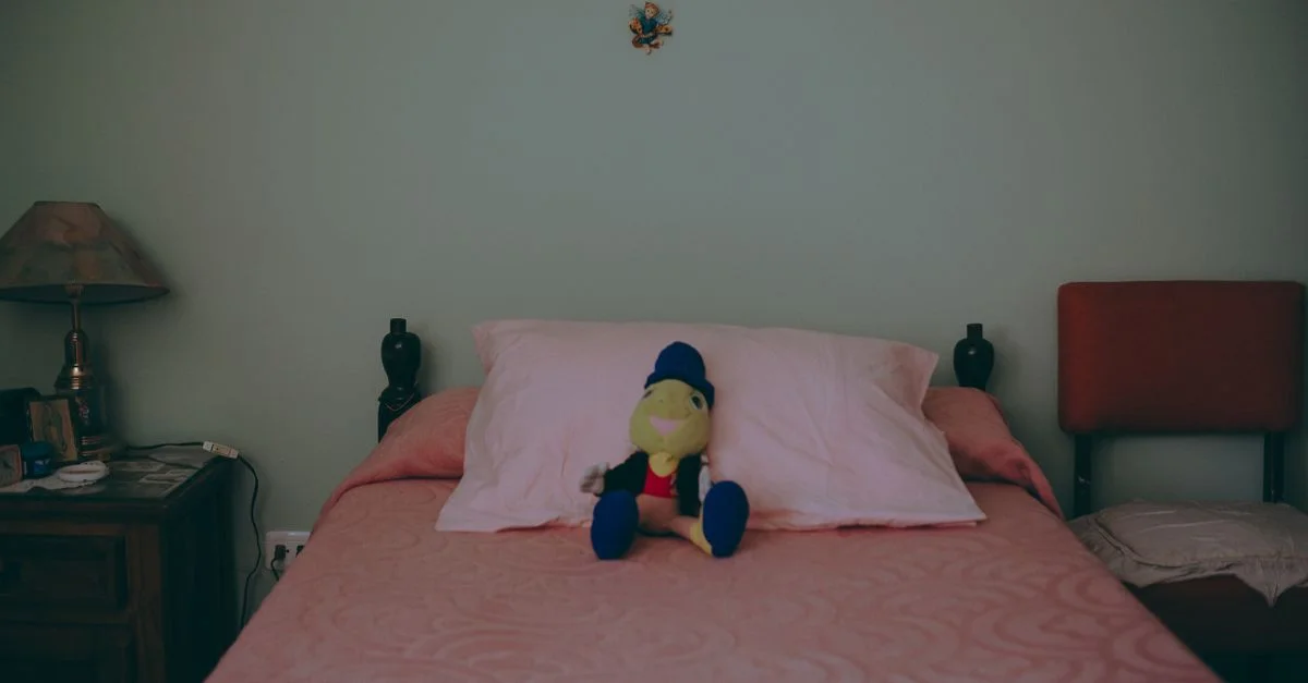 Une chambre douillette avec une peluche sur un lit bien fait, une ambiance parfaite pour une retraite sereine.